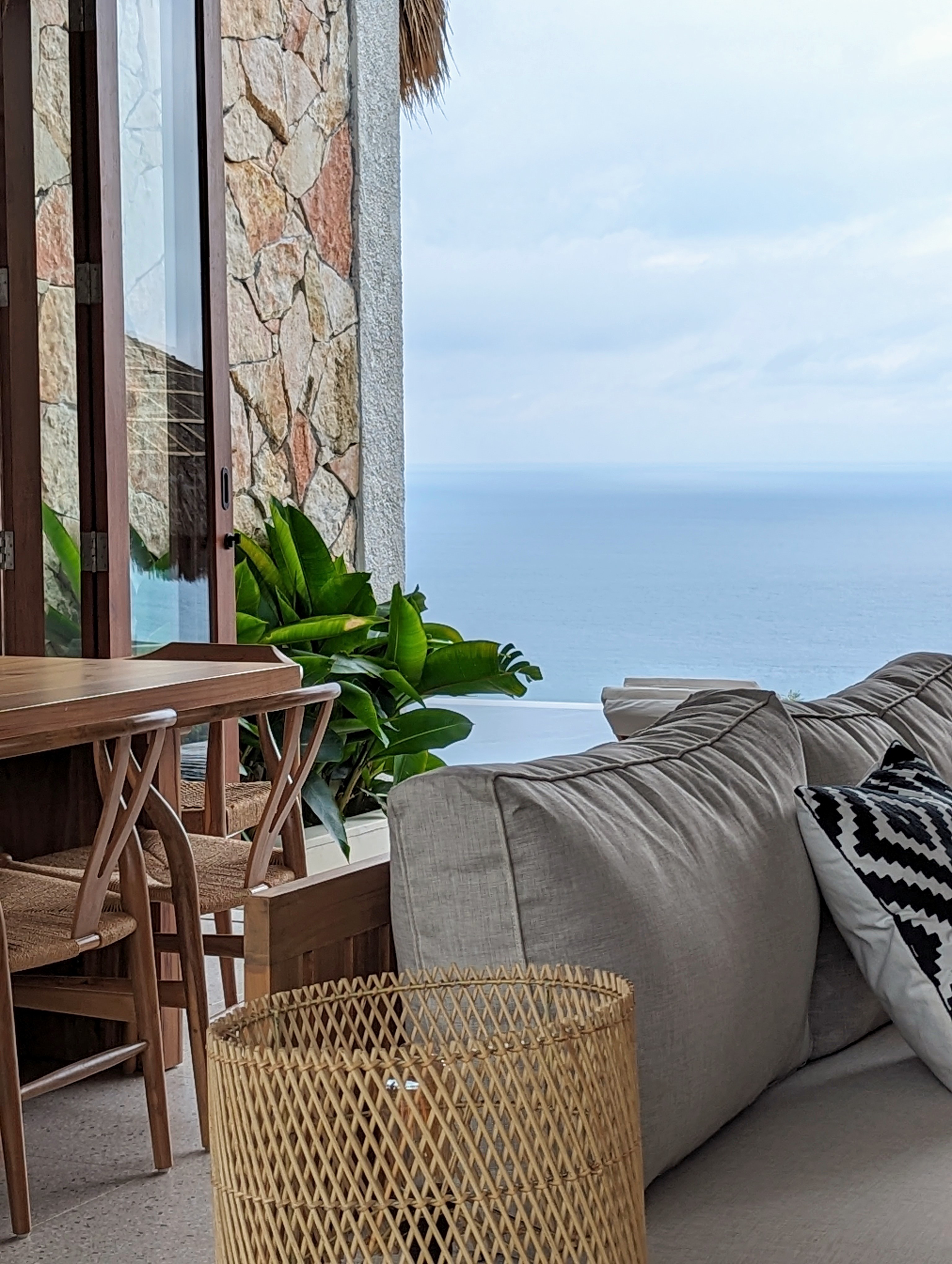Living room sofa and dining table with the sea beyond