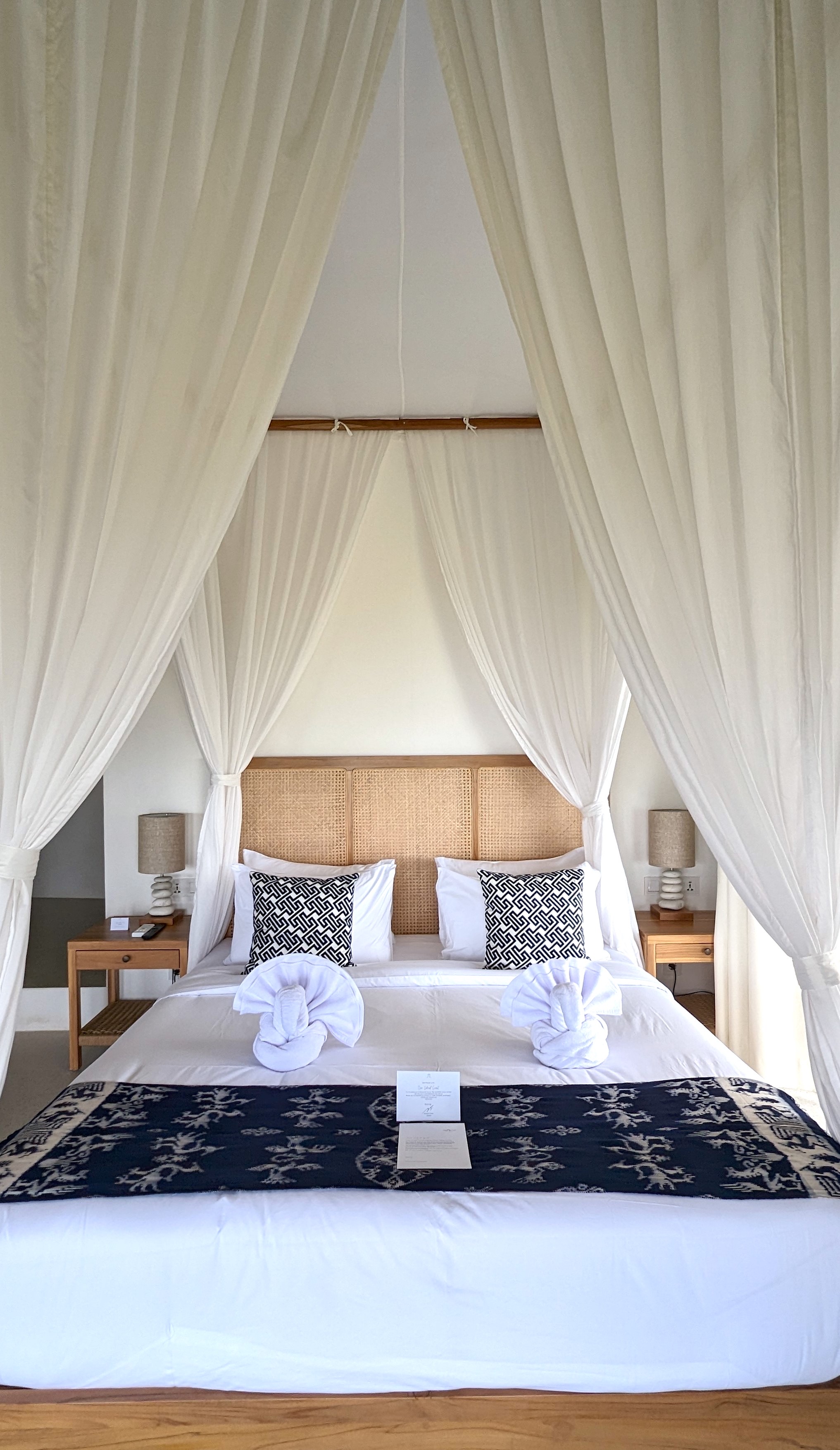 Bed with cane headboard and draped canopy