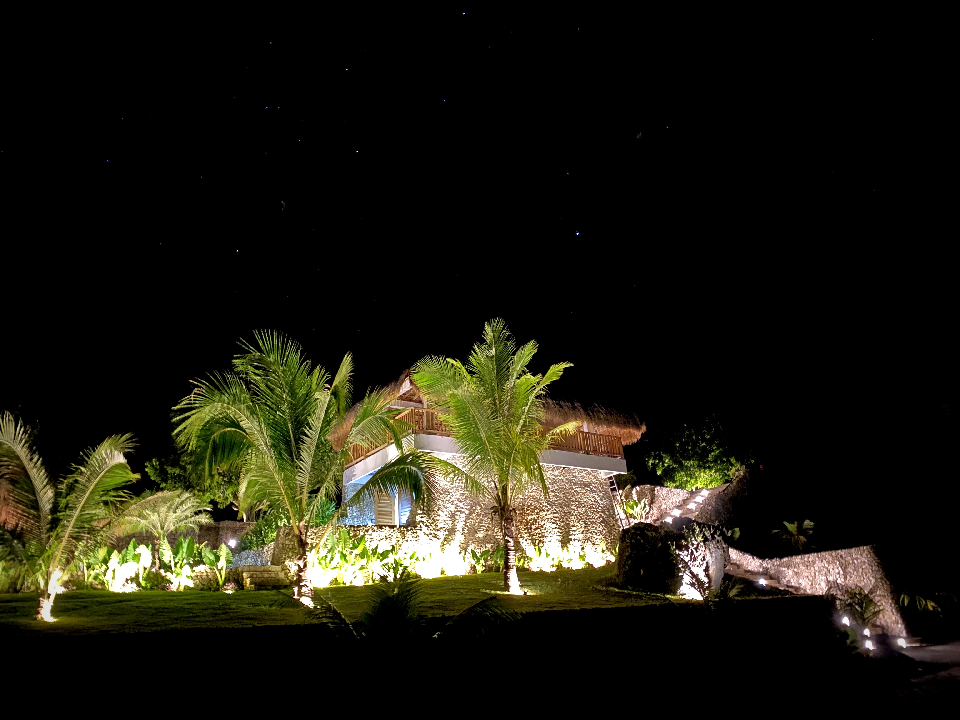 Beach dining setting with rattan pendant lamps at dusk